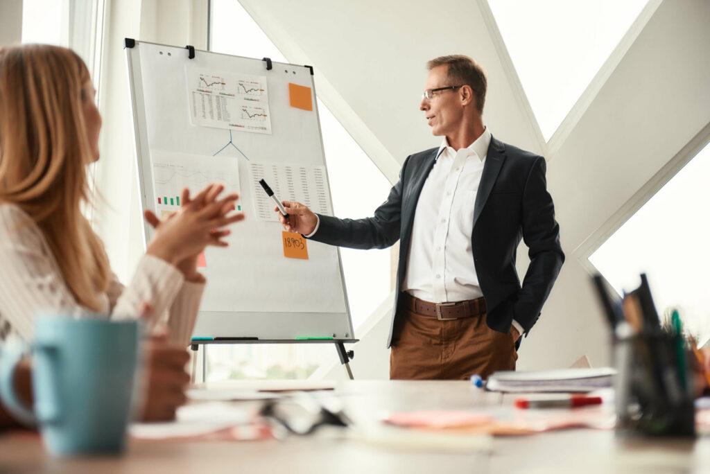Business owner presenting to a group at a whiteboard